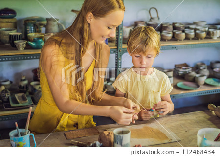 mother and son doing ceramic pot in pottery workshop 112468434