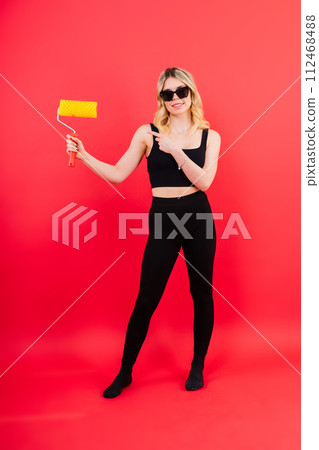 Young woman with roller brush on red white background Instruments accessories for renovation room Young woman with roller brush on red white background Instruments accessories for renovation room 112468488