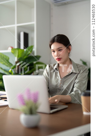 Businesswoman using laptop computer work from home in room. freelance, green room area, lifestyle concept Businesswoman using laptop computer work from home in room. freelance, green room area, lifestyle concept 112468530
