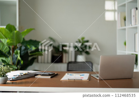 Empty workplace with desk and plant in office room, copy space. work from an atmospheric home office full of green plant Empty workplace with desk and plant in office room, copy space. work from an atmospheric home office full of green plant 112468535
