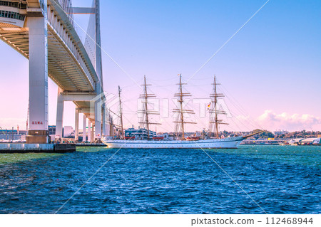 Japan's Yokohama cityscape - View of the Nippon Maru passing the Yokohama Bay Bridge from Daikoku Pier (toward Yamashita in the back) Japan's Yokohama cityscape - View of the Nippon Maru passing the Yokohama Bay Bridge from Daikoku Pier (toward Yamashita in the back) 112468944