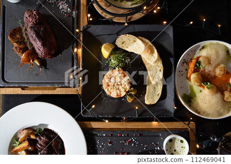 the table is covered with various meat dishes. delicious dishes are prepared for the celebration 112469041