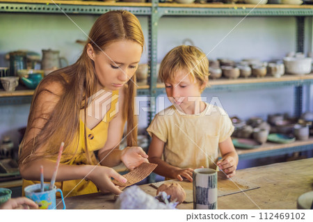 mother and son doing ceramic pot in pottery workshop mother and son doing ceramic pot in pottery workshop 112469102