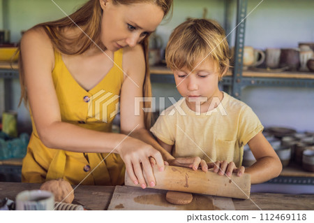 mother and son doing ceramic pot in pottery workshop 112469118