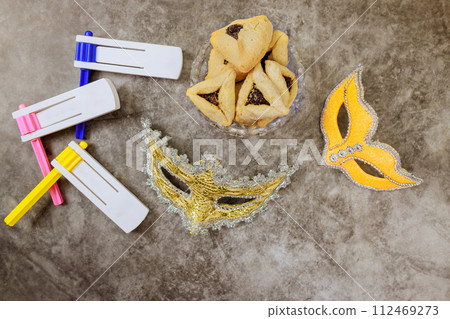As symbols of celebration, Jewish holiday Purim is associated with rattles, carnival masks, hamantaschen cookies 112469273