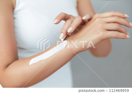 Closeup of female hands applying hand cream.Hand Skin Care. Women use body lotion on your arms. Beauty And Body Care Concept Closeup of female hands applying hand cream.Hand Skin Care. Women use body lotion on your arms. Beauty And Body Care Concept 112469959