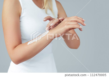 Closeup of female hands applying hand cream.Hand Skin Care. Women use body lotion on your arms. Beauty And Body Care Concept Closeup of female hands applying hand cream.Hand Skin Care. Women use body lotion on your arms. Beauty And Body Care Concept 112470005