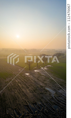 Sunrise Over a Dewy Farmland: A Portrait of Early Morning Agriculture 112470067