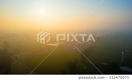 Misty Morning Glow Over Rural Landscape with Patches of Water Misty Morning Glow Over Rural Landscape with Patches of Water 112470073