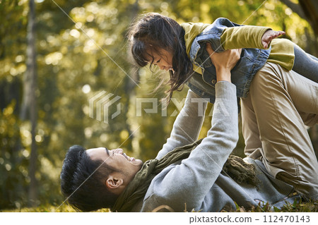 asian father and daughter having fun outdoors in park asian father and daughter having fun outdoors in park 112470143