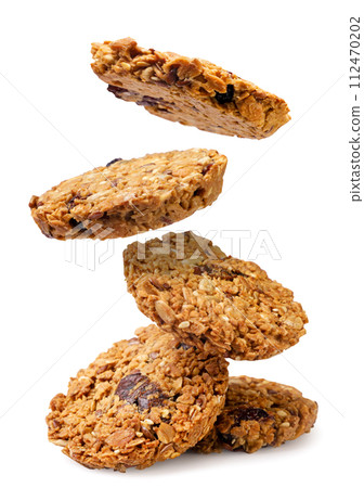 Granola cookies falling on a pile on a white background. Isolated 112470202