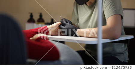 Woman master doing manicure to client in beauty salon 112470726