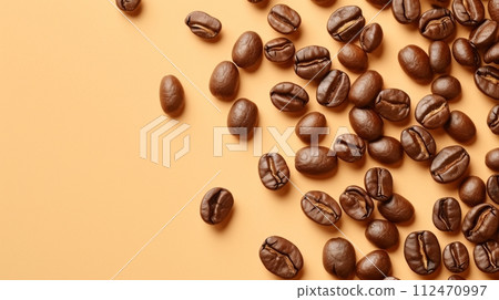 Coffee beans scattered on a beige background. Isolated on a solid color background. Coffee beans scattered on a beige background. Isolated on a solid color background. 112470997