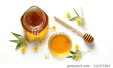 Hemp Honey and a wooden honey ladle on a white background with flowers.  112471067