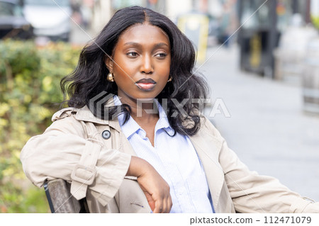 Serene Black Woman in Outdoor Urban Setting 112471079