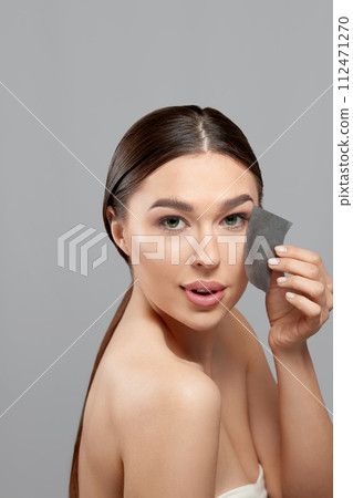 Skin Care. Woman removing oil from face using blotting papers. Closeup Portrait Of Beautiful Healthy Girl With Nude Makeup. Perfect Soft Skin With Oil Absorbing Tissue Sheets. Beauty Concept Skin Care. Woman removing oil from face using blotting papers. Closeup Portrait Of Beautiful Healthy Girl With Nude Makeup. Perfect Soft Skin With Oil Absorbing Tissue Sheets. Beauty Concept 112471270
