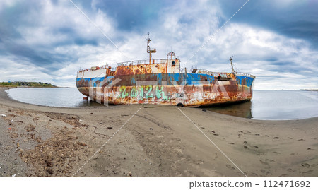 Abandoned Rusty Shipwreck on a Desolate Beach Landscape 112471692