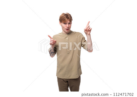 young surprised red-haired man in a beige shirt on a white background young surprised red-haired man in a beige shirt on a white background 112471702