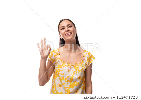 young pretty brunette woman dressed in a summer yellow t-shirt on a white background young pretty brunette woman dressed in a summer yellow t-shirt on a white background 112471728