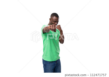 young leader african man dressed in a green t-shirt and jeans actively gesturing on a white 112471757