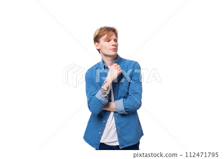 a young red-haired guy in a blue denim shirt actively gesticulates. advertising concept 112471795