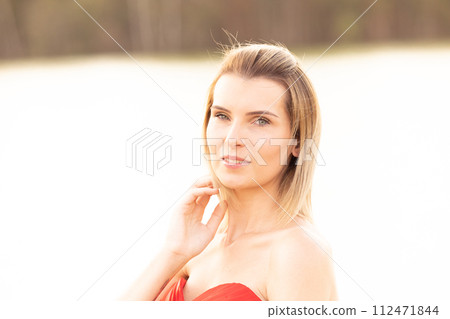Serene Beauty: Young Woman in Sun-Drenched Portrait 112471844