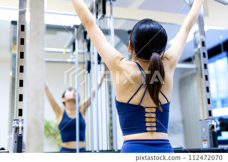 Woman training her body at the gym, lat pulldown, muscle training girl's back workout Woman training her body at the gym, lat pulldown, muscle training girl's back workout 112472070