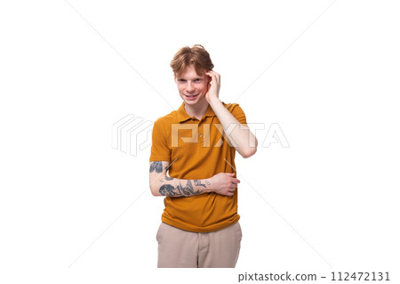 a young man with red hair in an orange T-shirt stands thoughtfully a young man with red hair in an orange T-shirt stands thoughtfully 112472131