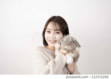 A smiling woman holding a rabbit A smiling woman holding a rabbit 112472269