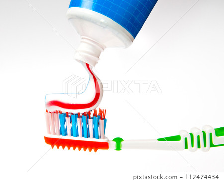 toothpaste being squeezed onto toothbrush toothpaste being squeezed onto toothbrush 112474434