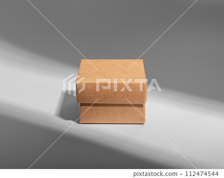 Small little kraft box in light beam, ray 112474544
