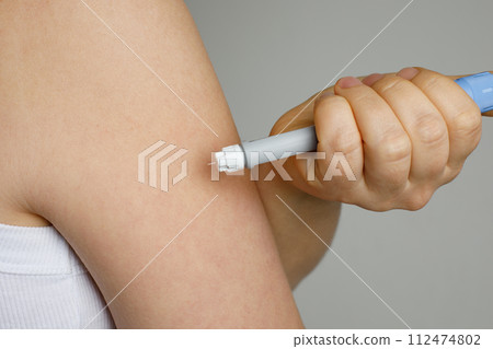 Self injection pen in female hand. Medicine and treatment concept 112474802