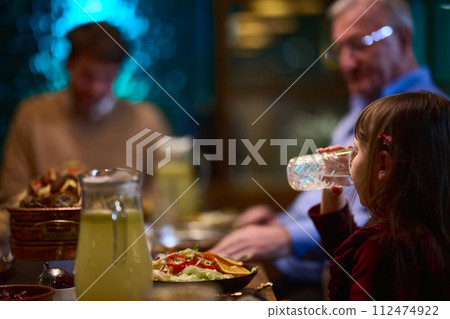 In a modern restaurant, a young girl participates in iftar by breaking her fast with water, embodying the tradition and significance of Ramadan in a contemporary setting. In a modern restaurant, a young girl participates in iftar by breaking her fast with water, embodying the tradition and significance of Ramadan in a contemporary setting. 112474922