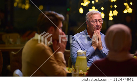In a modern restaurant setting, a European Islamic family comes together for iftar during Ramadan, engaging in prayer before the meal, uniting tradition and contemporary practices in a celebration of In a modern restaurant setting, a European Islamic family comes together for iftar during Ramadan, engaging in prayer before the meal, uniting tradition and contemporary practices in a celebration of 112474941
