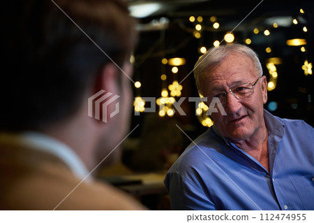 A son and his elderly father engage in heartfelt conversation while patiently awaiting their iftar meal, fostering intergenerational bonding and cherished moments of family connection A son and his elderly father engage in heartfelt conversation while patiently awaiting their iftar meal, fostering intergenerational bonding and cherished moments of family connection 112474955
