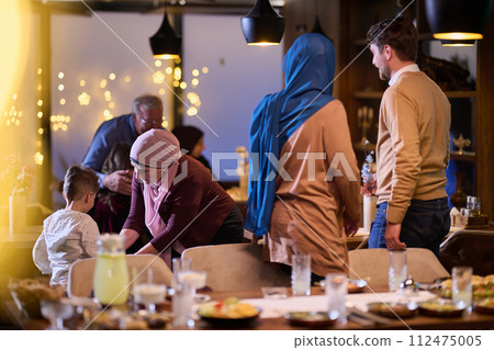 Grandparents arrive at their children's and grandchildren's gathering for iftar in a restaurant during the holy month of Ramadan, bearing gifts and sharing cherished moments of love, unity, and Grandparents arrive at their children's and grandchildren's gathering for iftar in a restaurant during the holy month of Ramadan, bearing gifts and sharing cherished moments of love, unity, and 112475005