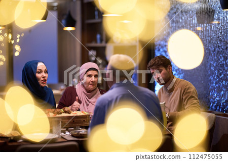 A modern and traditional European Islamic family comes together for iftar in a contemporary restaurant during the Ramadan fasting period, embodying cultural harmony and familial unity amidst a 112475055