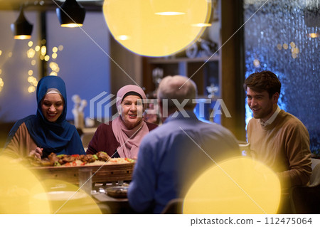 A modern and traditional European Islamic family comes together for iftar in a contemporary restaurant during the Ramadan fasting period, embodying cultural harmony and familial unity amidst a 112475064