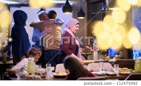 Grandparents arrive at their children's and grandchildren's gathering for iftar in a restaurant during the holy month of Ramadan, bearing gifts and sharing cherished moments of love, unity, and Grandparents arrive at their children's and grandchildren's gathering for iftar in a restaurant during the holy month of Ramadan, bearing gifts and sharing cherished moments of love, unity, and 112475092