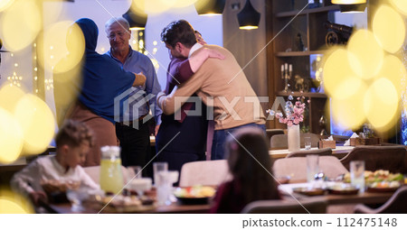 Grandparents arrive at their children's and grandchildren's gathering for iftar in a restaurant during the holy month of Ramadan, bearing gifts and sharing cherished moments of love, unity, and Grandparents arrive at their children's and grandchildren's gathering for iftar in a restaurant during the holy month of Ramadan, bearing gifts and sharing cherished moments of love, unity, and 112475148