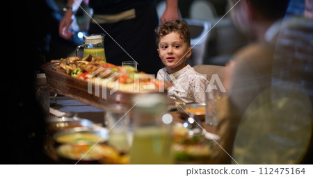 In a heartwarming scene, a professional chef serves an European Muslim family their iftar meal during the holy month of Ramadan, embodying cultural unity and culinary hospitality in a moment of shared 112475164