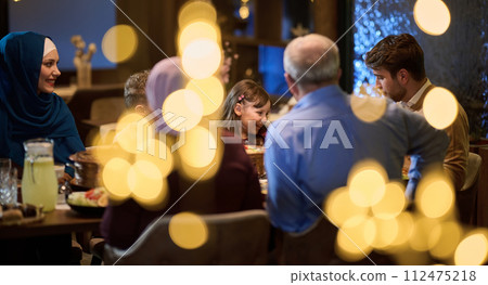 A modern and traditional European Islamic family comes together for iftar in a contemporary restaurant during the Ramadan fasting period, embodying cultural harmony and familial unity amidst a A modern and traditional European Islamic family comes together for iftar in a contemporary restaurant during the Ramadan fasting period, embodying cultural harmony and familial unity amidst a 112475218