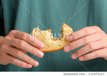 Female hands holding a bitten peanut butter sandwich with honey of wheat bread, close up 112475227