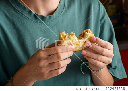 Female hands holding a bitten peanut butter sandwich with honey of wheat bread 112475228