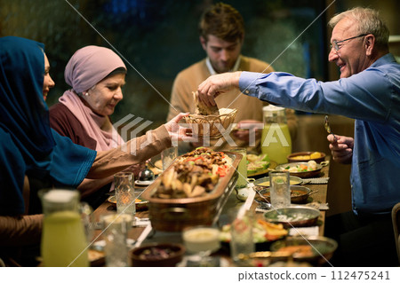 A modern and traditional European Islamic family comes together for iftar in a contemporary restaurant during the Ramadan fasting period, embodying cultural harmony and familial unity amidst a A modern and traditional European Islamic family comes together for iftar in a contemporary restaurant during the Ramadan fasting period, embodying cultural harmony and familial unity amidst a 112475241