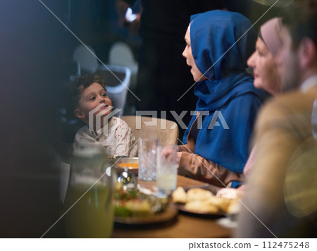 In a heartwarming scene, a professional chef serves an European Muslim family their iftar meal during the holy month of Ramadan, embodying cultural unity and culinary hospitality in a moment of shared In a heartwarming scene, a professional chef serves an European Muslim family their iftar meal during the holy month of Ramadan, embodying cultural unity and culinary hospitality in a moment of shared 112475248