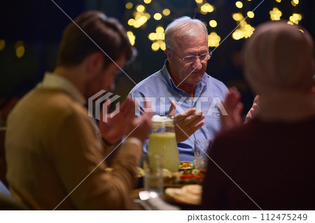 In a modern restaurant setting, a European Islamic family comes together for iftar during Ramadan, engaging in prayer before the meal, uniting tradition and contemporary practices in a celebration of In a modern restaurant setting, a European Islamic family comes together for iftar during Ramadan, engaging in prayer before the meal, uniting tradition and contemporary practices in a celebration of 112475249