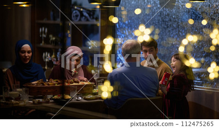 A modern and traditional European Islamic family comes together for iftar in a contemporary restaurant during the Ramadan fasting period, embodying cultural harmony and familial unity amidst a A modern and traditional European Islamic family comes together for iftar in a contemporary restaurant during the Ramadan fasting period, embodying cultural harmony and familial unity amidst a 112475265