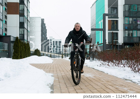 European elderly man doing sports and riding a bicycle European elderly man doing sports and riding a bicycle 112475444