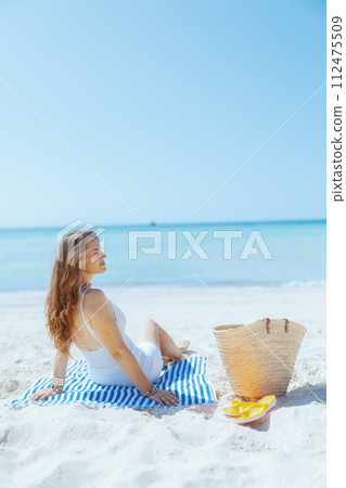 relaxed modern 40 years old woman on ocean shore 112475509
